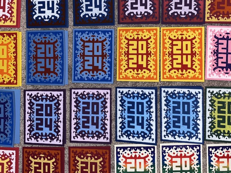 Happy New Year 2024 prints on carpeted floor to dry.